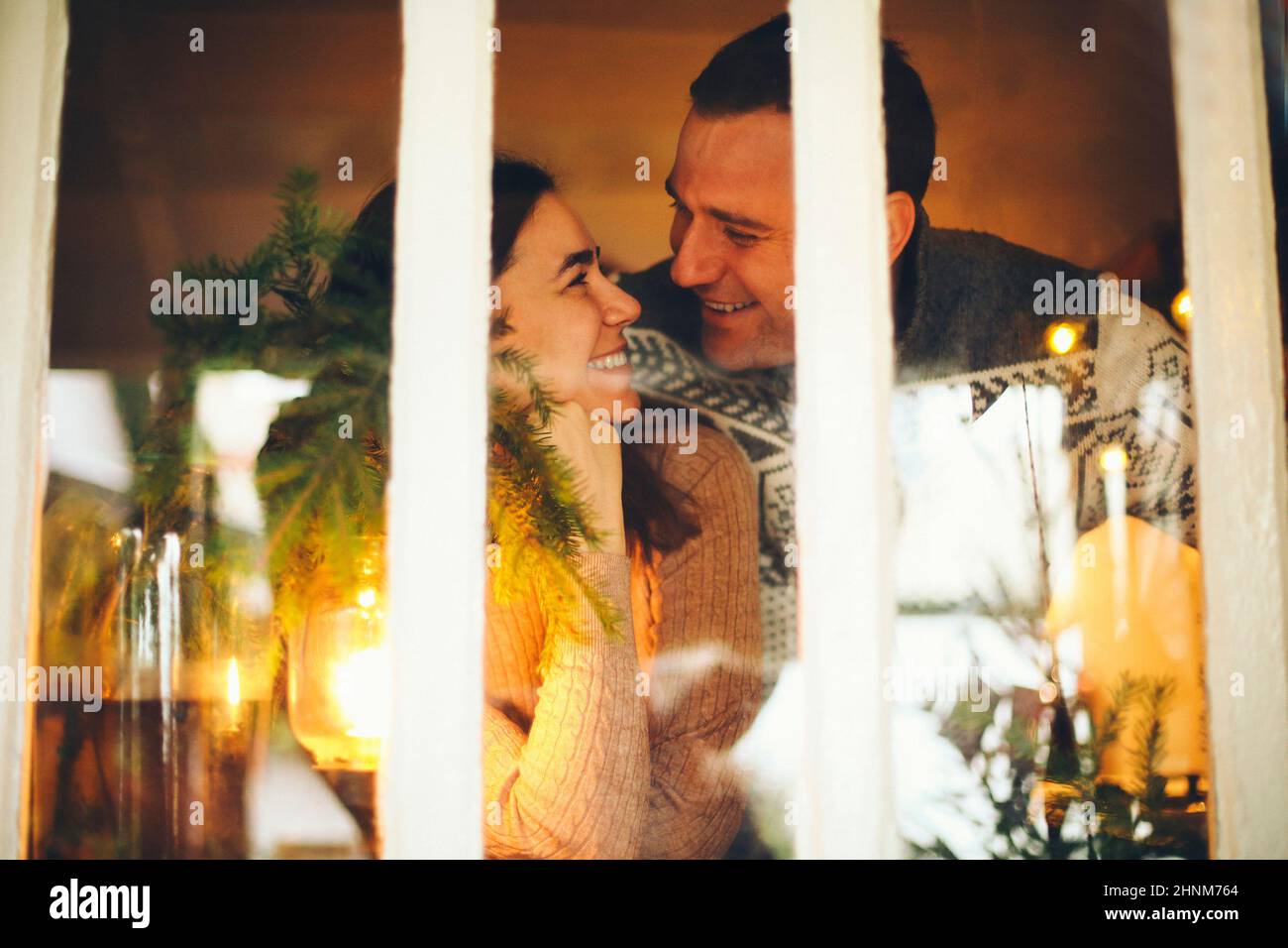 Portrait of happy family couple man and woman smiling at camera while spending winter holidays together in cozy warm festive homely atmosphere. People Stock Photo