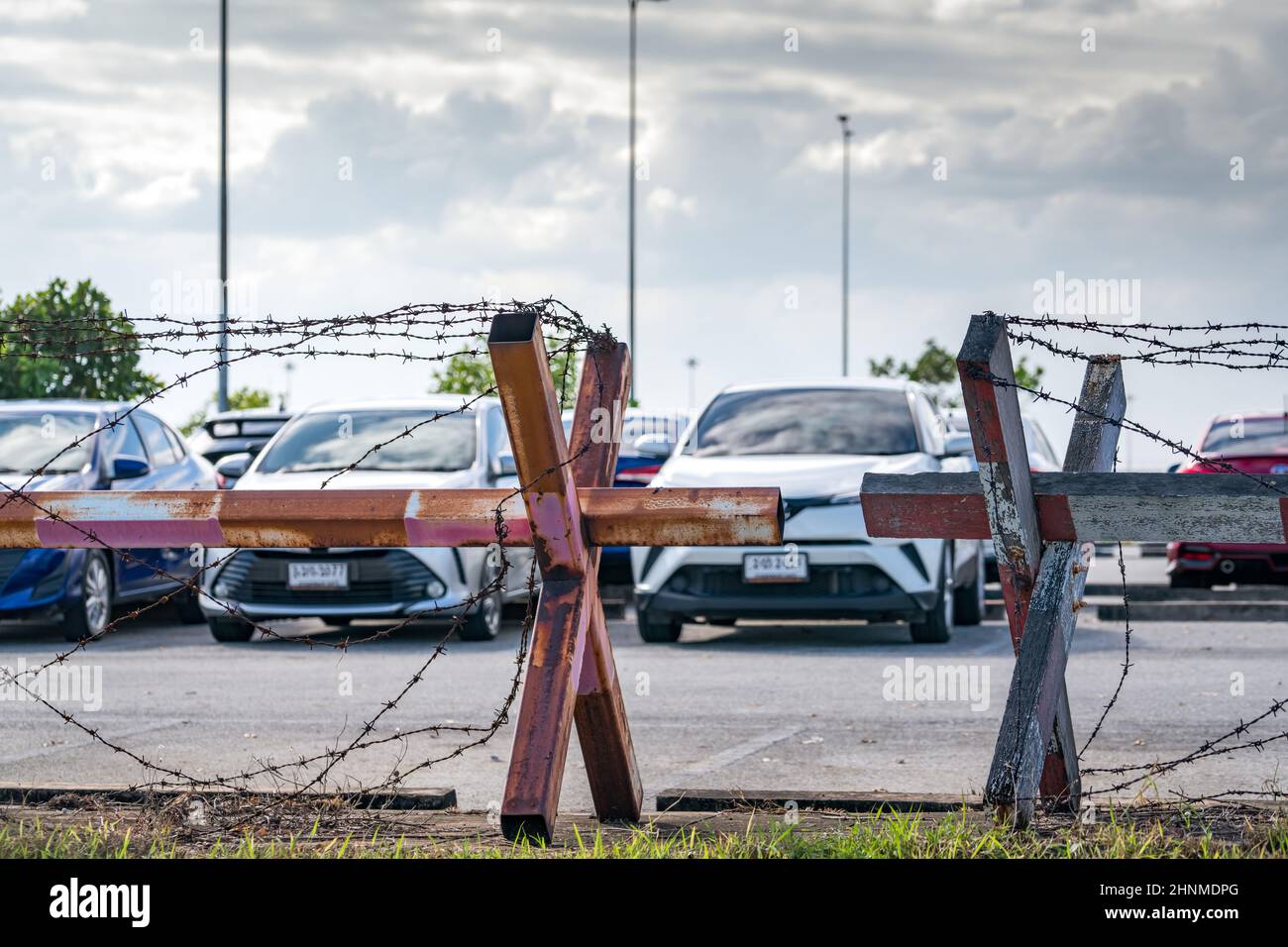 Barbed wire fence of the parking lot. Cars parked at outdoor car parking lot. Car was seized by a lending company. Financial crisis impact on car loan. Used car business. Auto leasing and insurance. Stock Photo