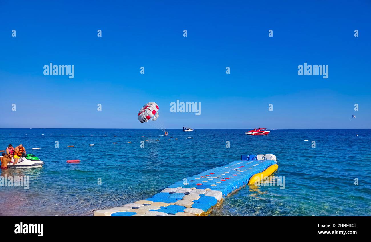 Parasailing in a blue sky near sea beach. Parasailing is a popular recreational activity among tourists in Turkey. For editorial use only. Stock Photo