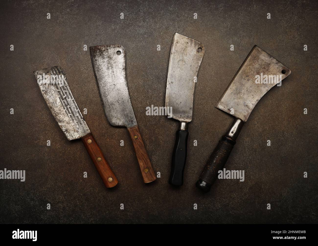 Close up vintage butcher meat cleavers on cutting board or grunge brown