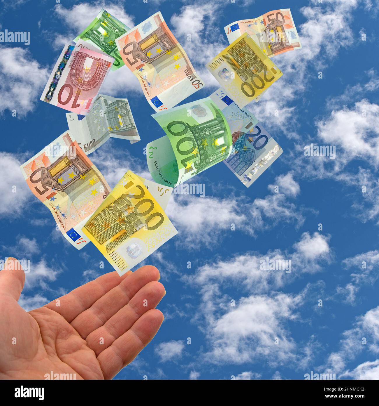 Opened hand and banknotes against sky with clouds Stock Photo