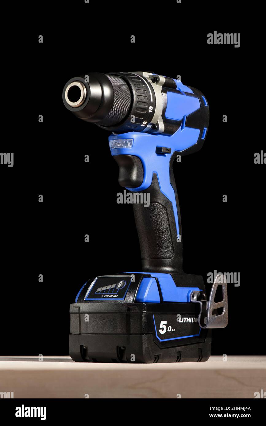 https://c8.alamy.com/comp/2HNMJ4A/cordless-drill-stands-on-a-wooden-table-on-a-black-background-cordless-drill-with-lithium-ion-battery-in-blue-professional-tool-for-drilling-holes-2HNMJ4A.jpg