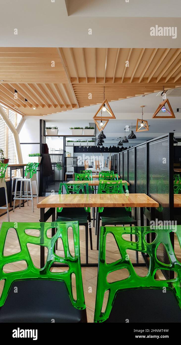 Cafeteria, no people dining room with wooden tables and green chairs