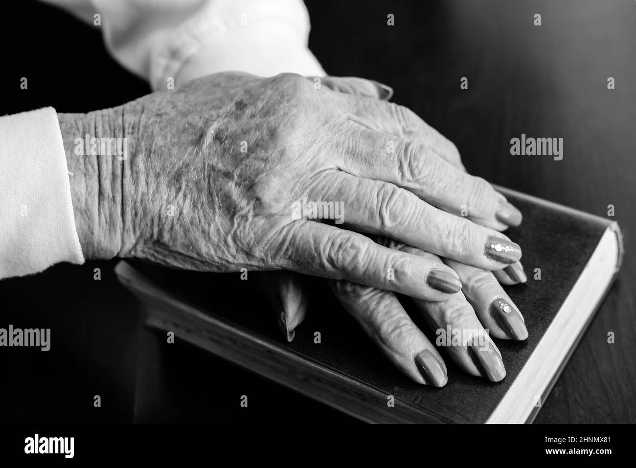 A close up concept photo of a pair of wringled and aged hands from an elederly woman. Stock Photo