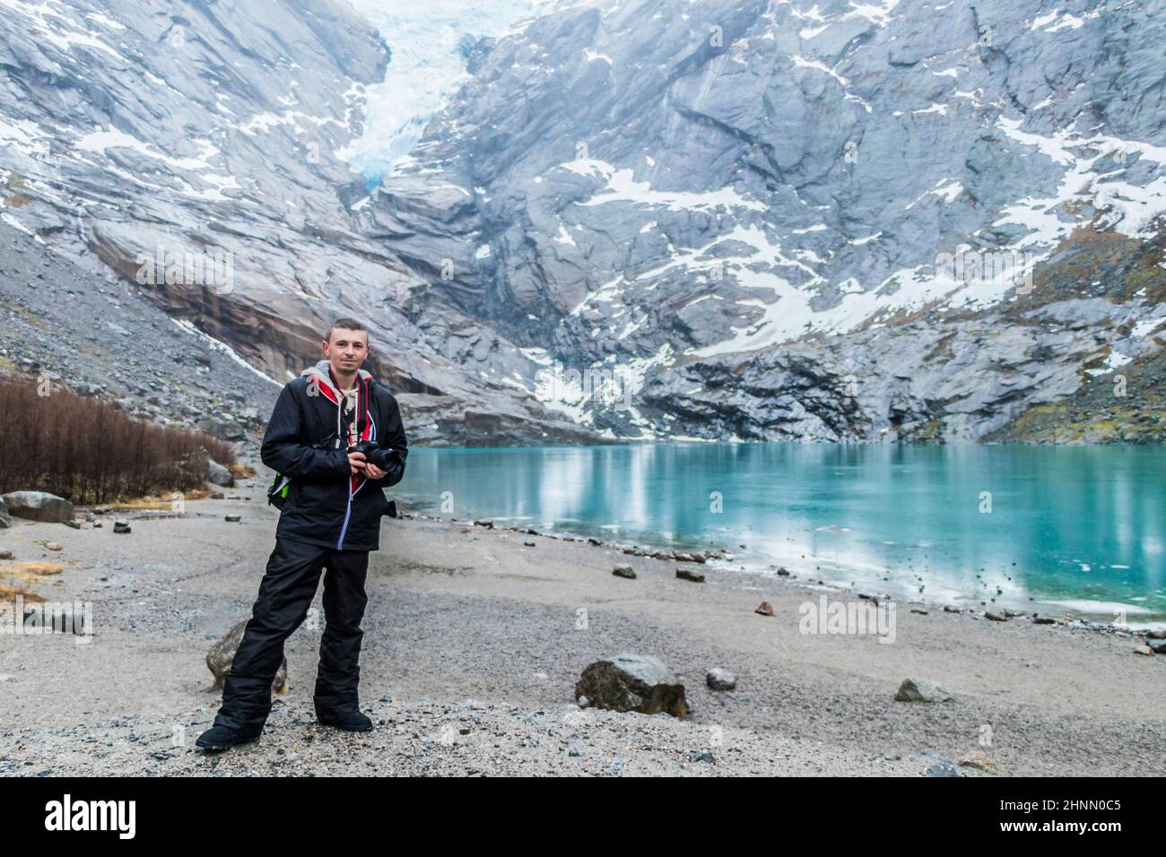 Tourist at amazing Briksdalsbre Briksdalsbreen glacier in the winder Norway. Stock Photo