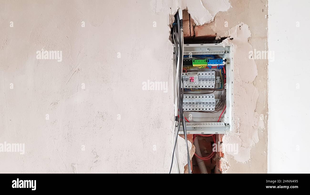 Electrical safety in homes, switchboard panel with switches. Home electrical system in the apartment under repair. Circuit breakers with wires in an electric screen with copy space. Stock Photo