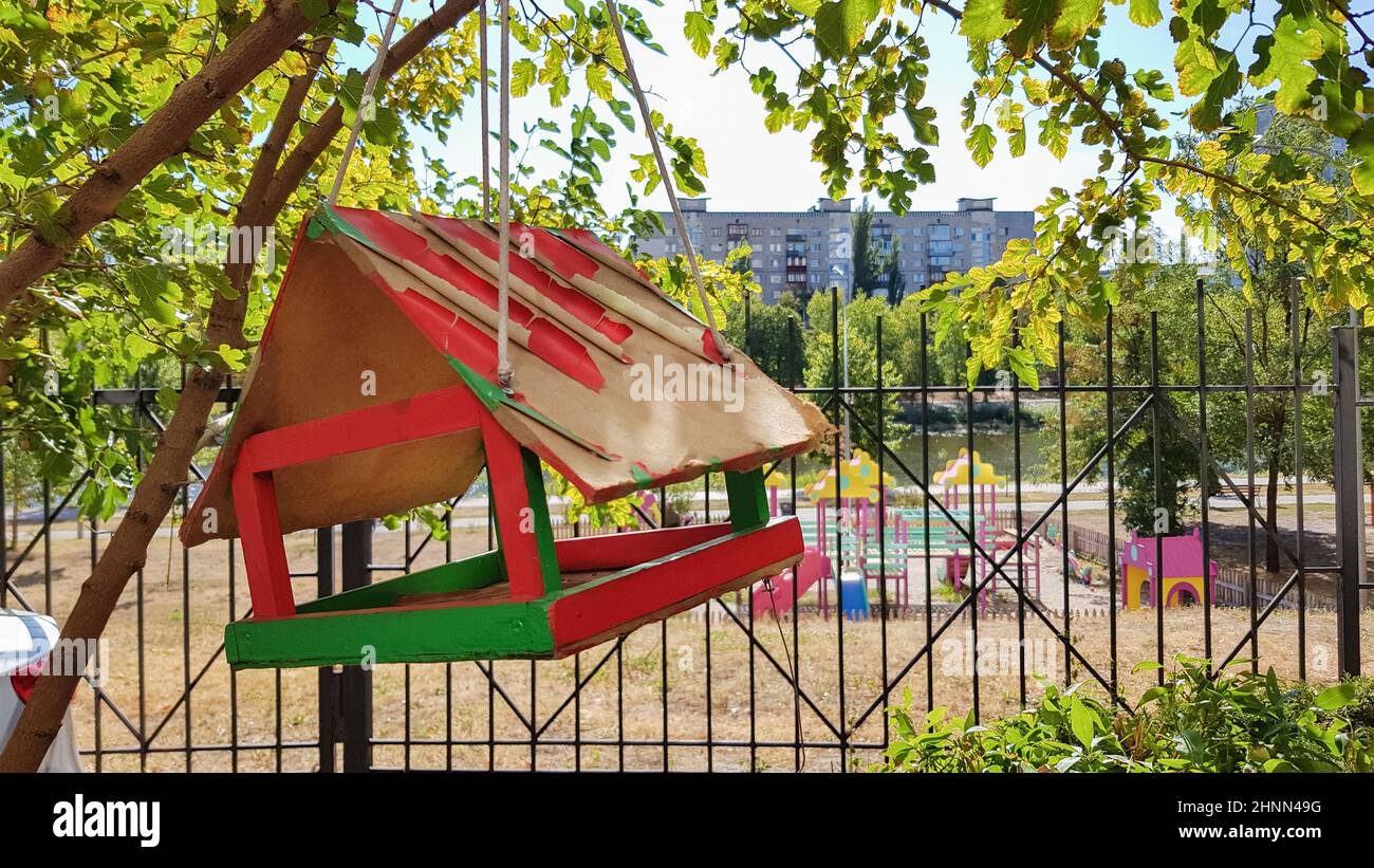 Handmade bird feeders made of wood in a city park. Bird house. Stock Photo