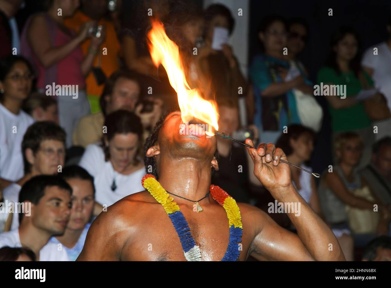 fire dancer keeps his tongue to the torch Stock Photo