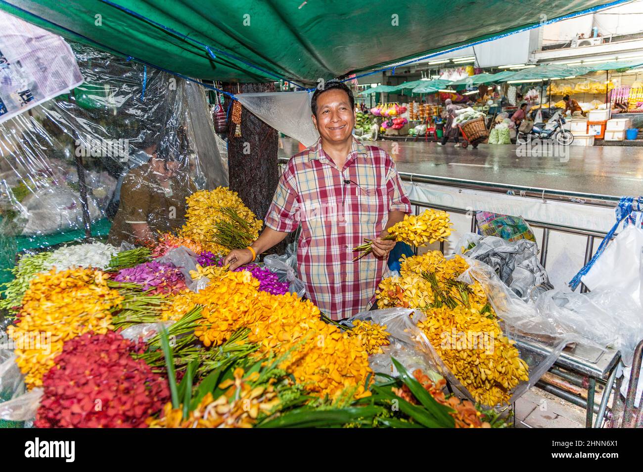 man sells  flowers at the nightly flower market Pak Klong Thalat in Bangkok Stock Photo