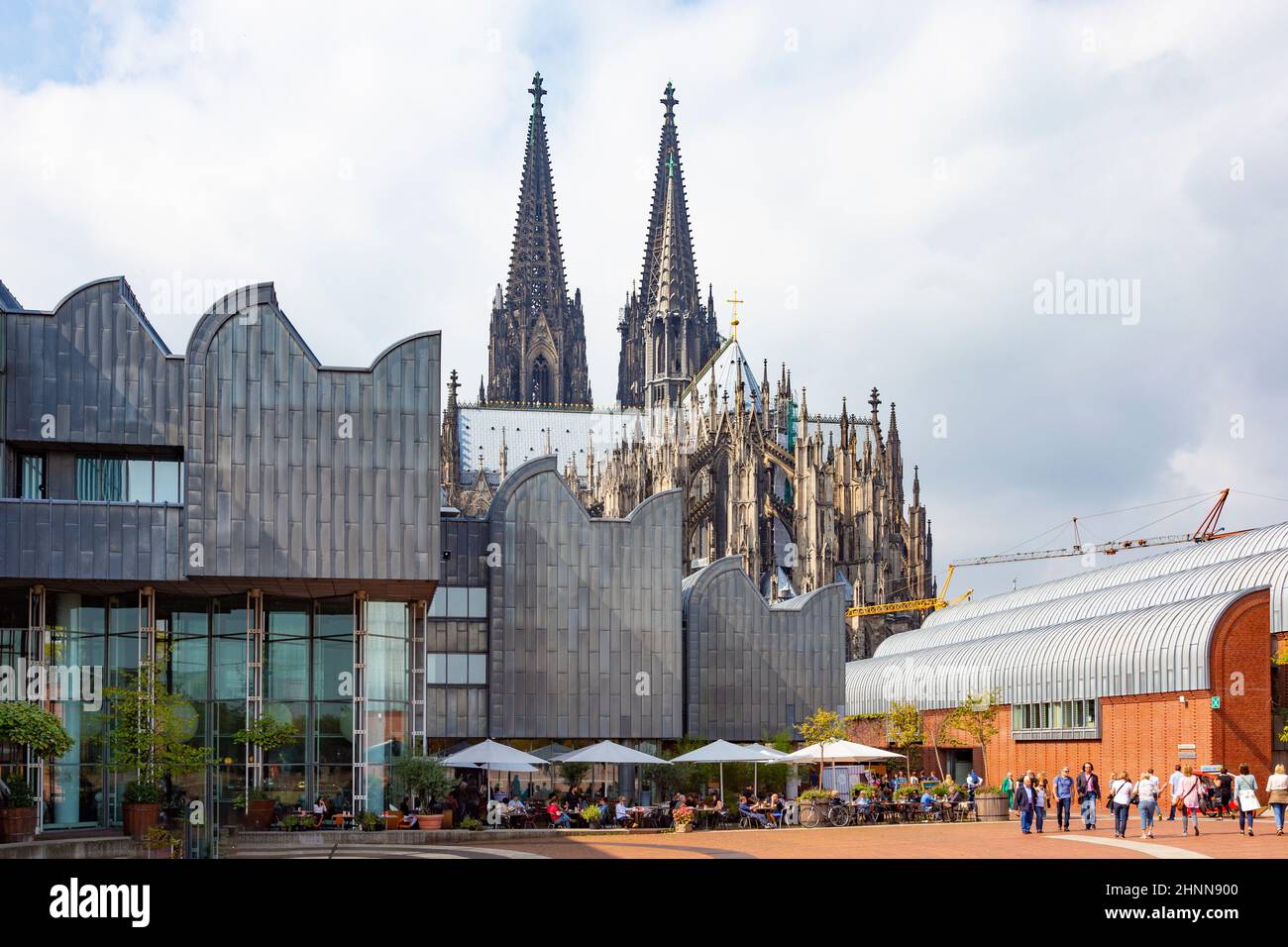 exterior shot of the Ludwig Museum, outdoor cafe and the two towers of the Cologne Cathedral Stock Photo