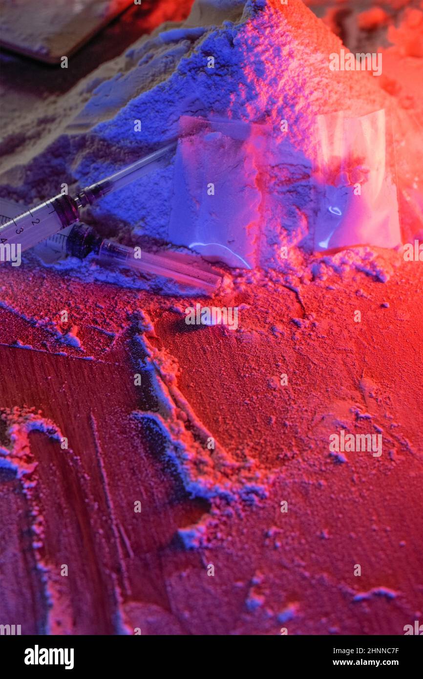 Drugs, drug dealer's house. Cocaine packaged in sachets, scales tablets and syringes in neon