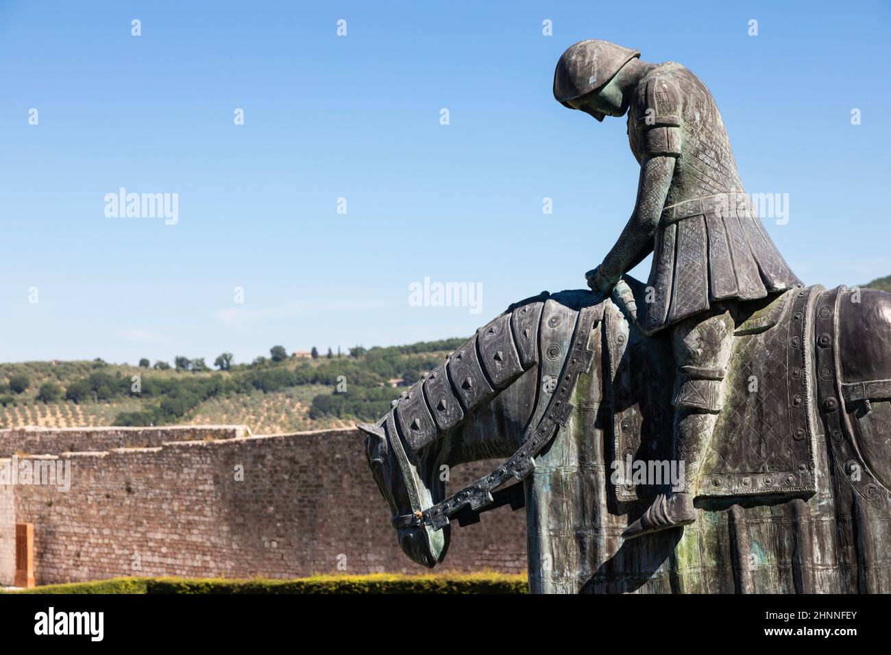 Assisi village in Umbria region, Italy. Statue of St. Francis. The town is famous for the most important Italian Basilica dedicated to St. Francis - San Francesco. Stock Photo