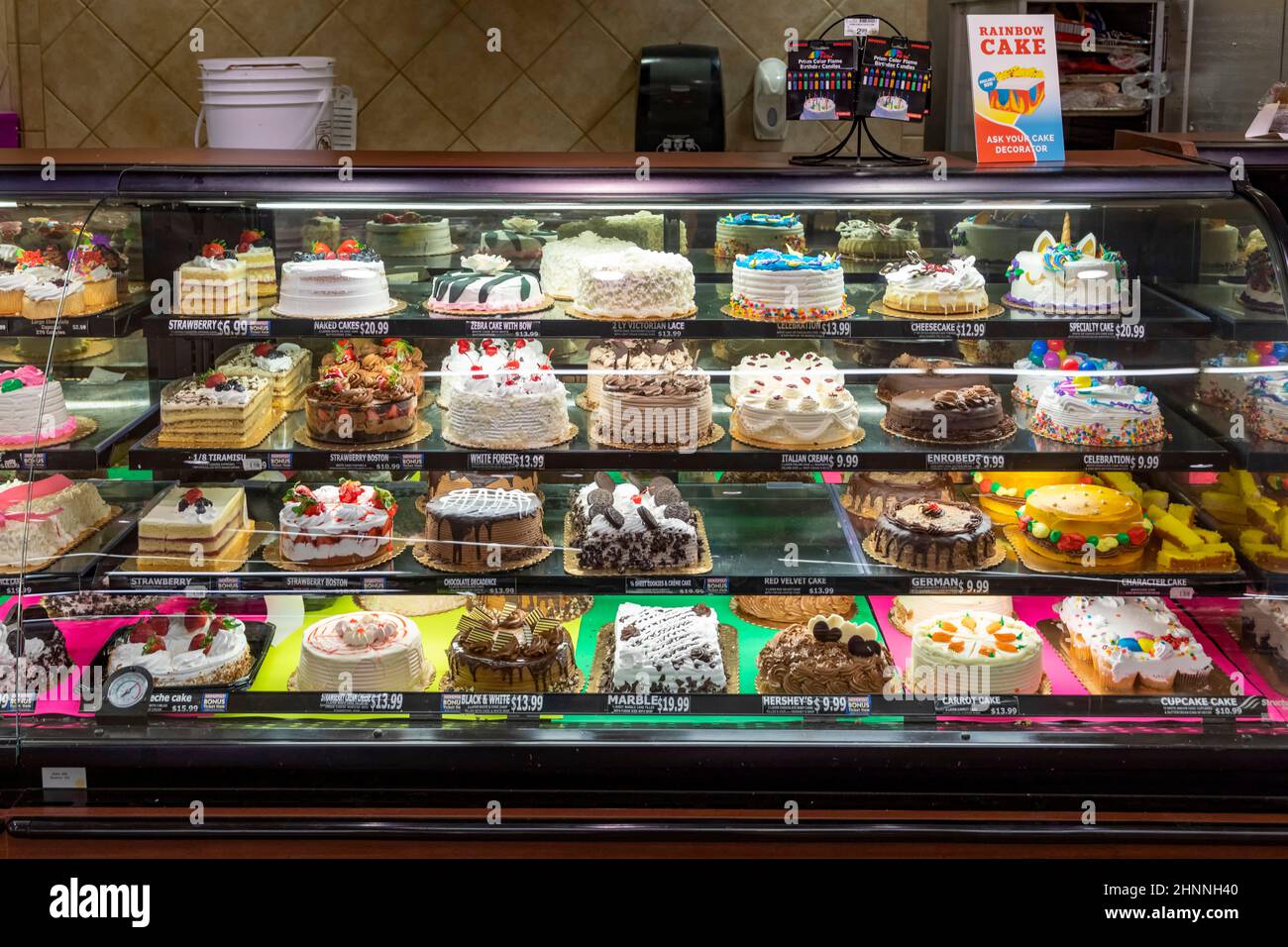 different sweet cakes in the showcase of an american confectioner store. Stock Photo