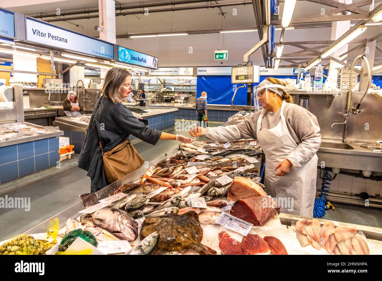 people go shopping in the central market in Portimao but wearing mouth protection to protect against Corona Stock Photo