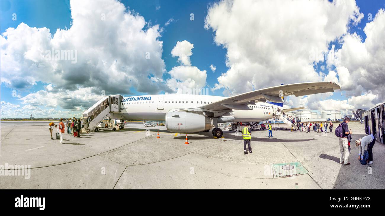 people are boarding the aircraft with distance and face masks at Frankfurt airport Stock Photo