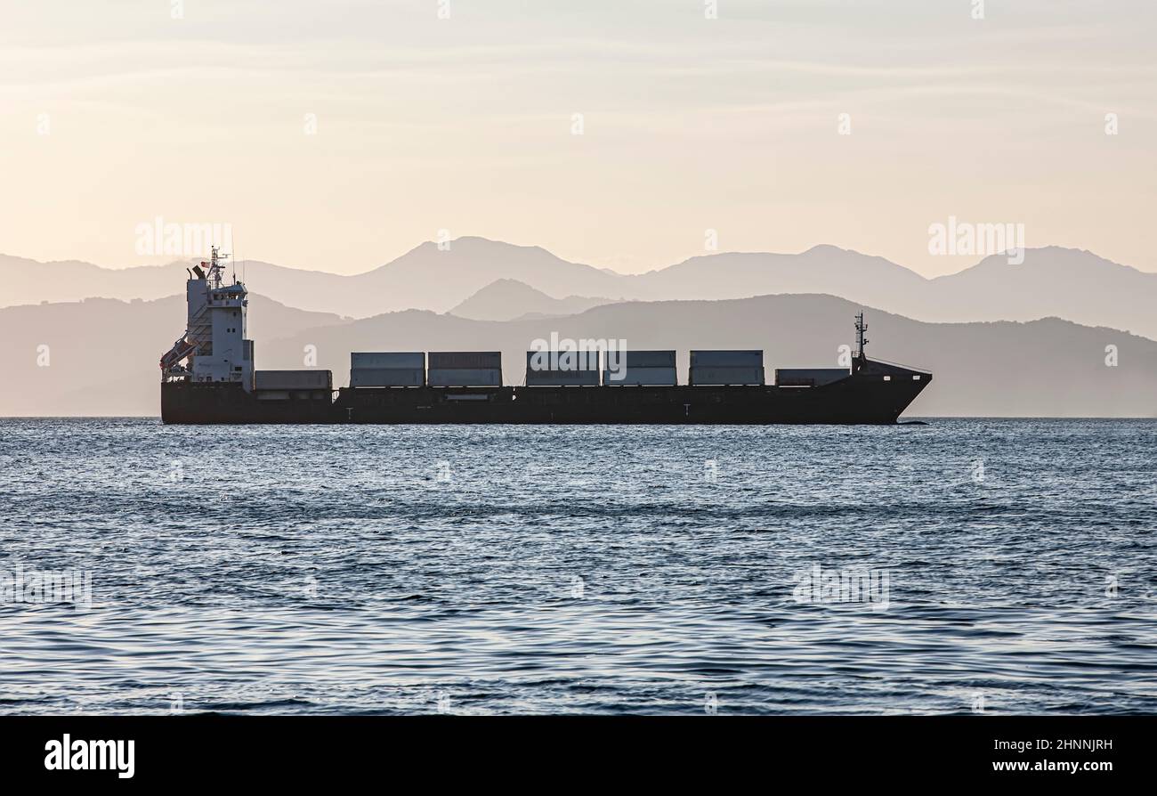cargo  ship on the background of blurred mountains Stock Photo
