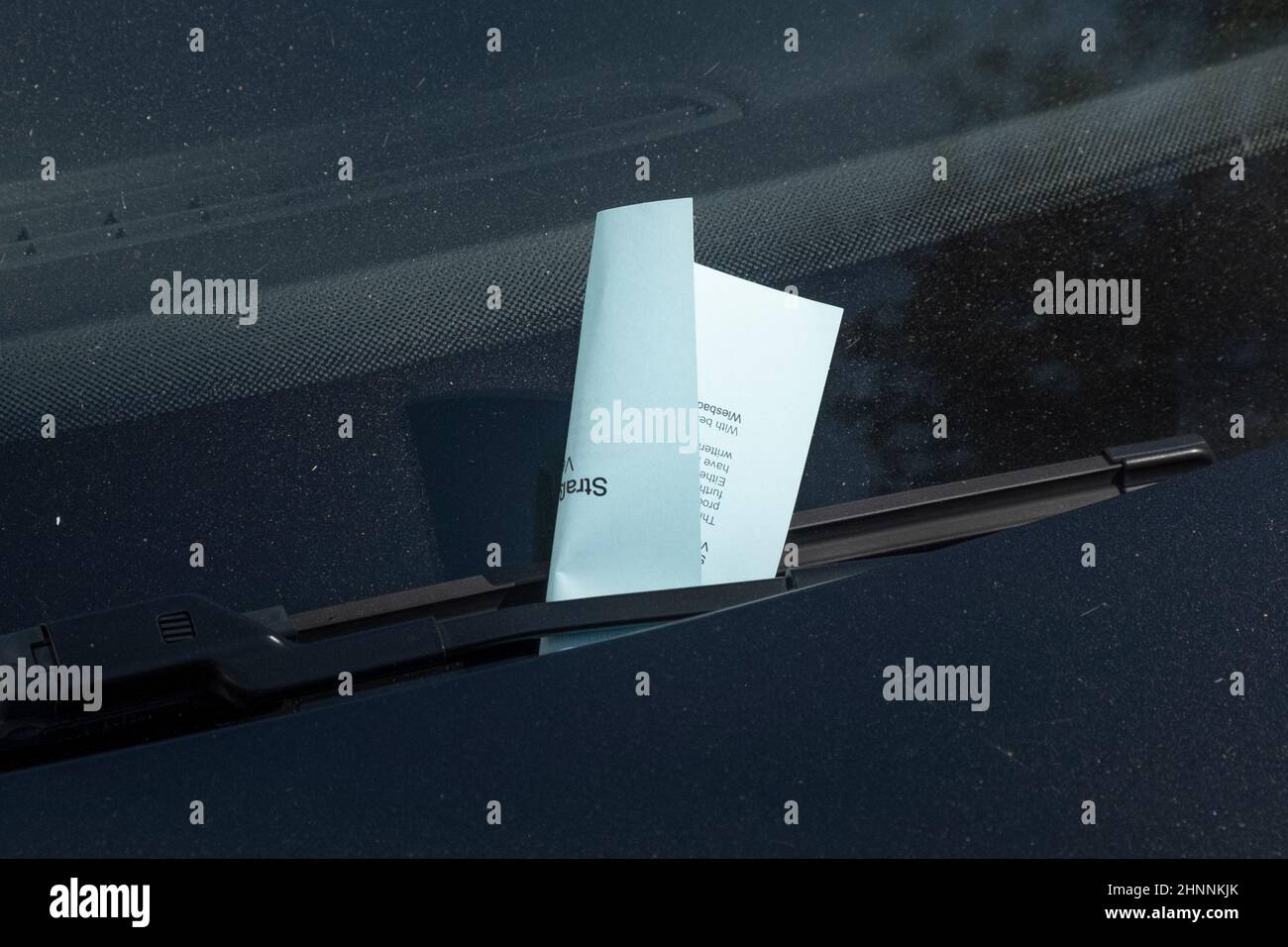 parking ticket placed on the wiper at the windshield of a car in Wiesbaden Stock Photo