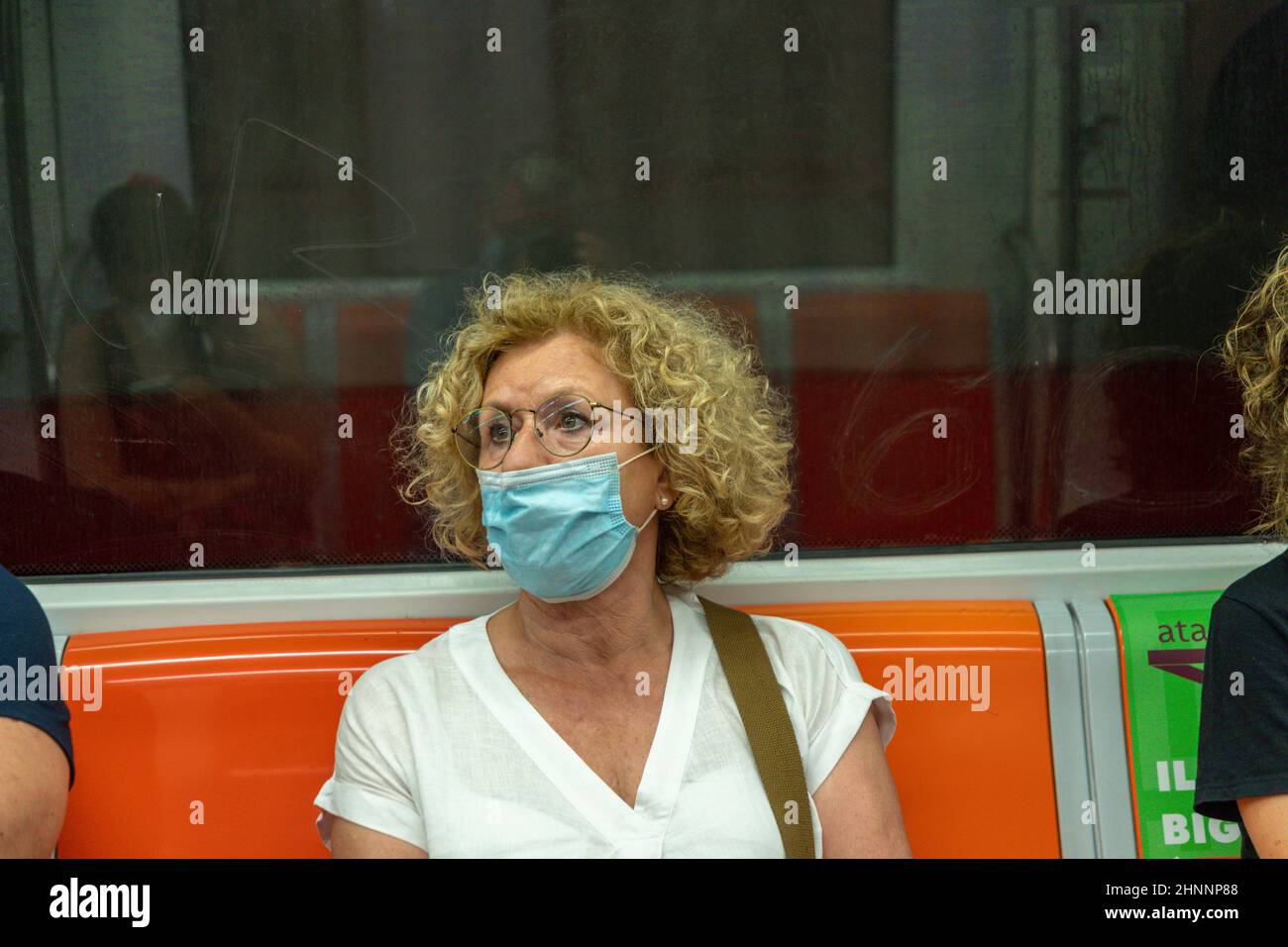 people in the Metro protect themselves by wearing a medical mask in Rome, Italy Stock Photo