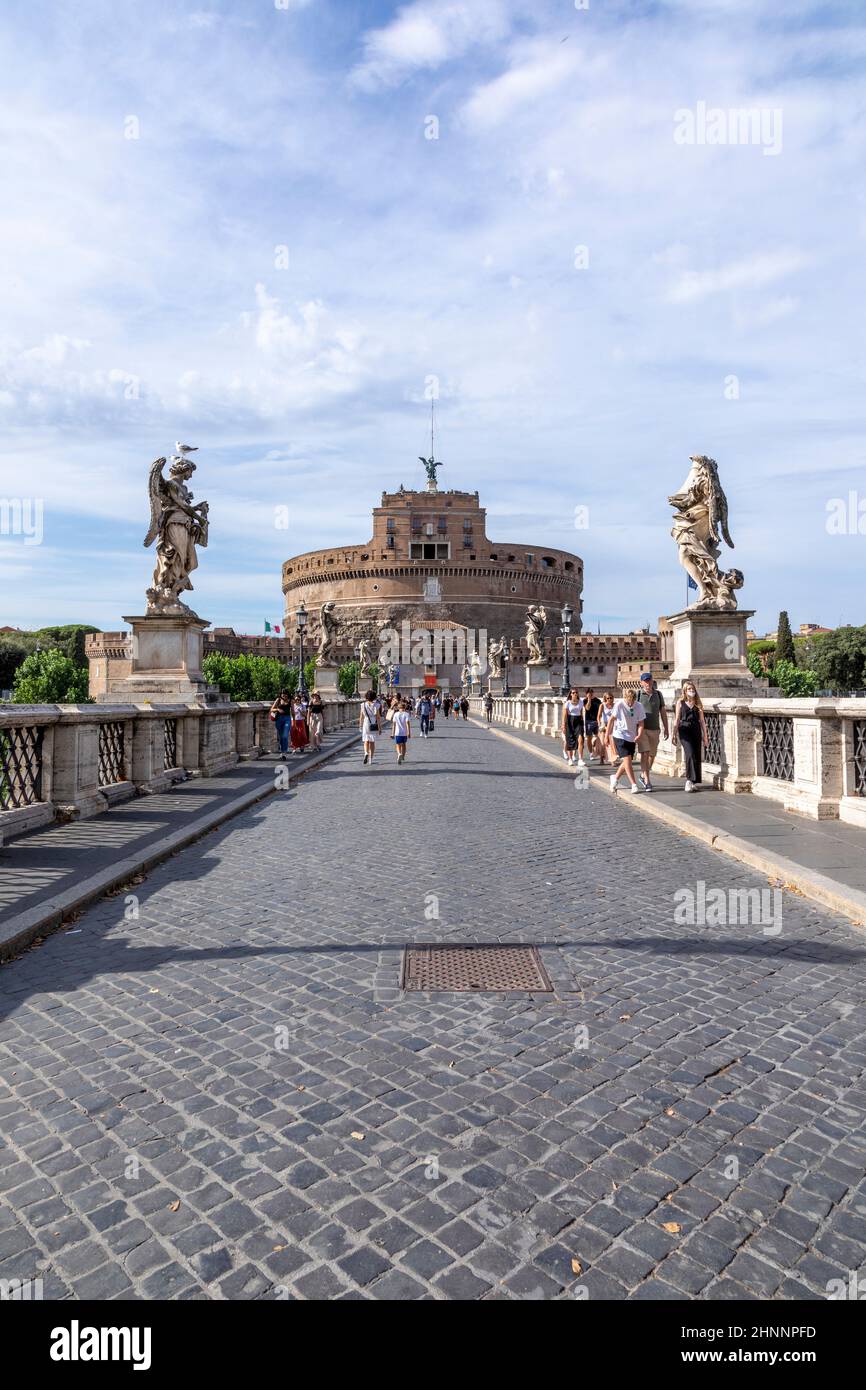 people enjoy visiting the castle of the holy angel in Rome by crossing the river Tiber at the bridge of holy angels in Rome, Italy. Stock Photo