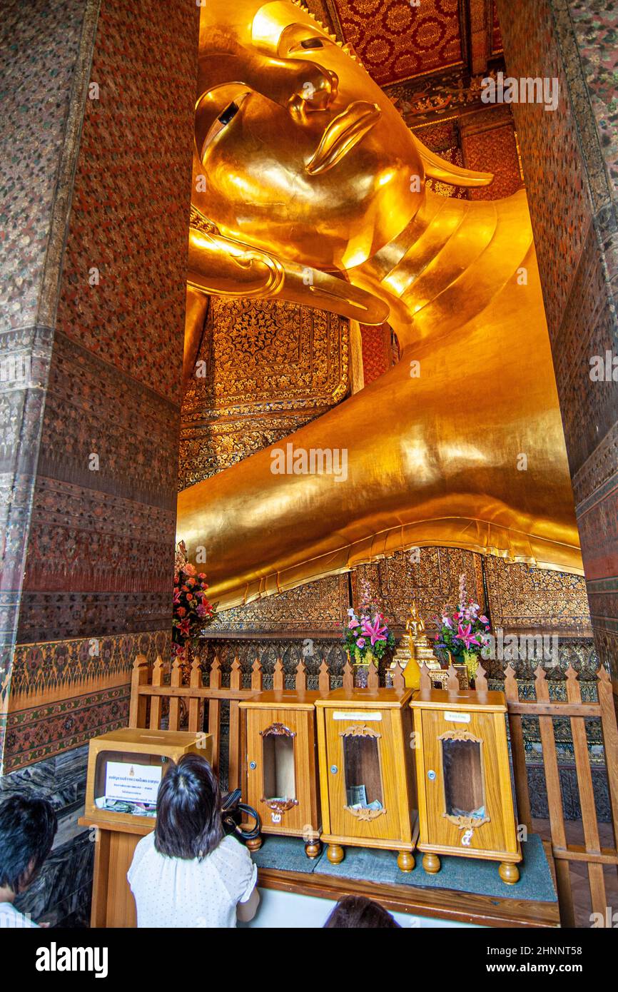 people pray to lying buddha in Wat Pho, temple of first royal class in