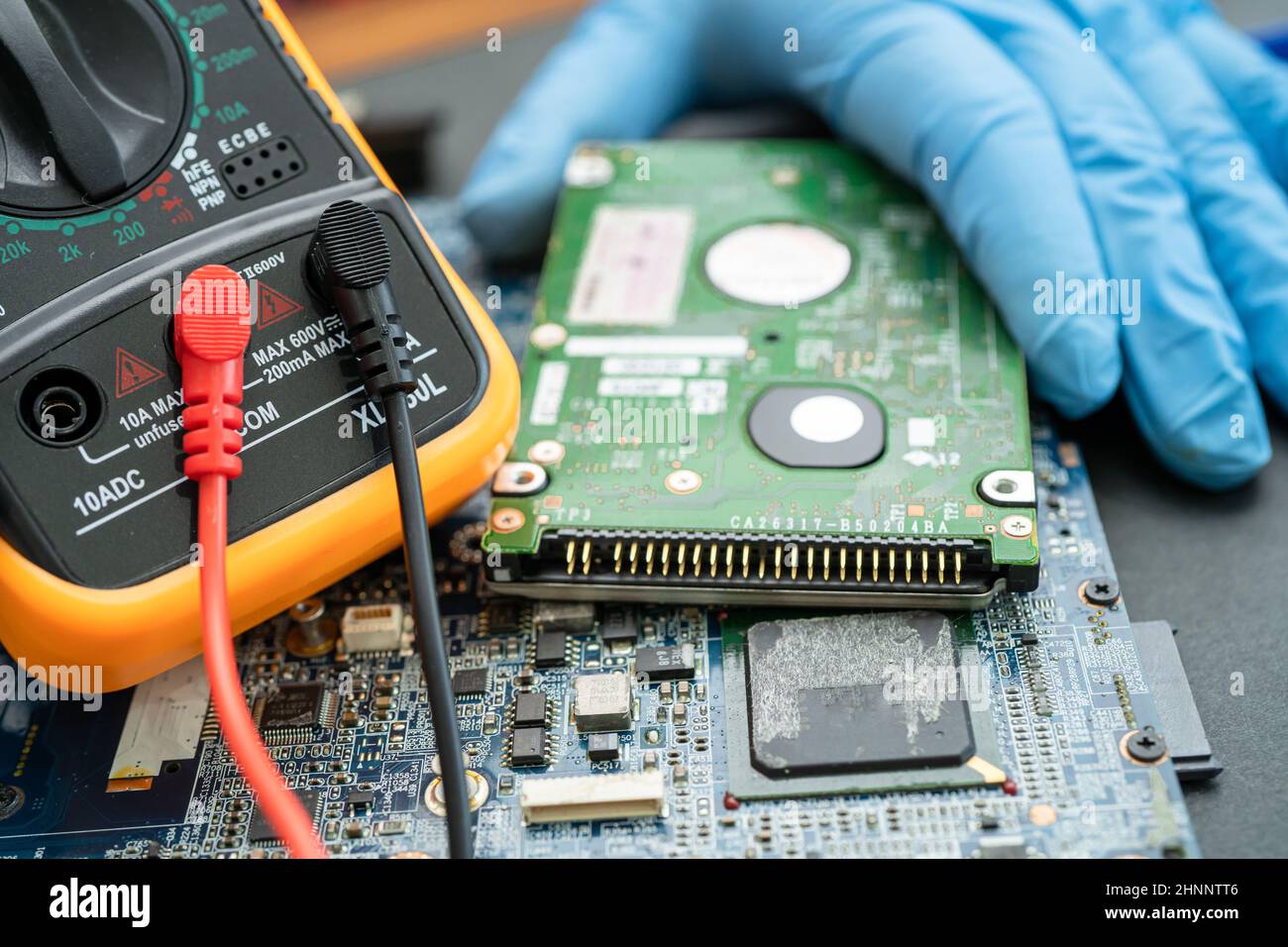 technician repairing inside of hard disk by soldering iron. Integrated Circuit. the concept of data, hardware, technician and technology. Stock Photo