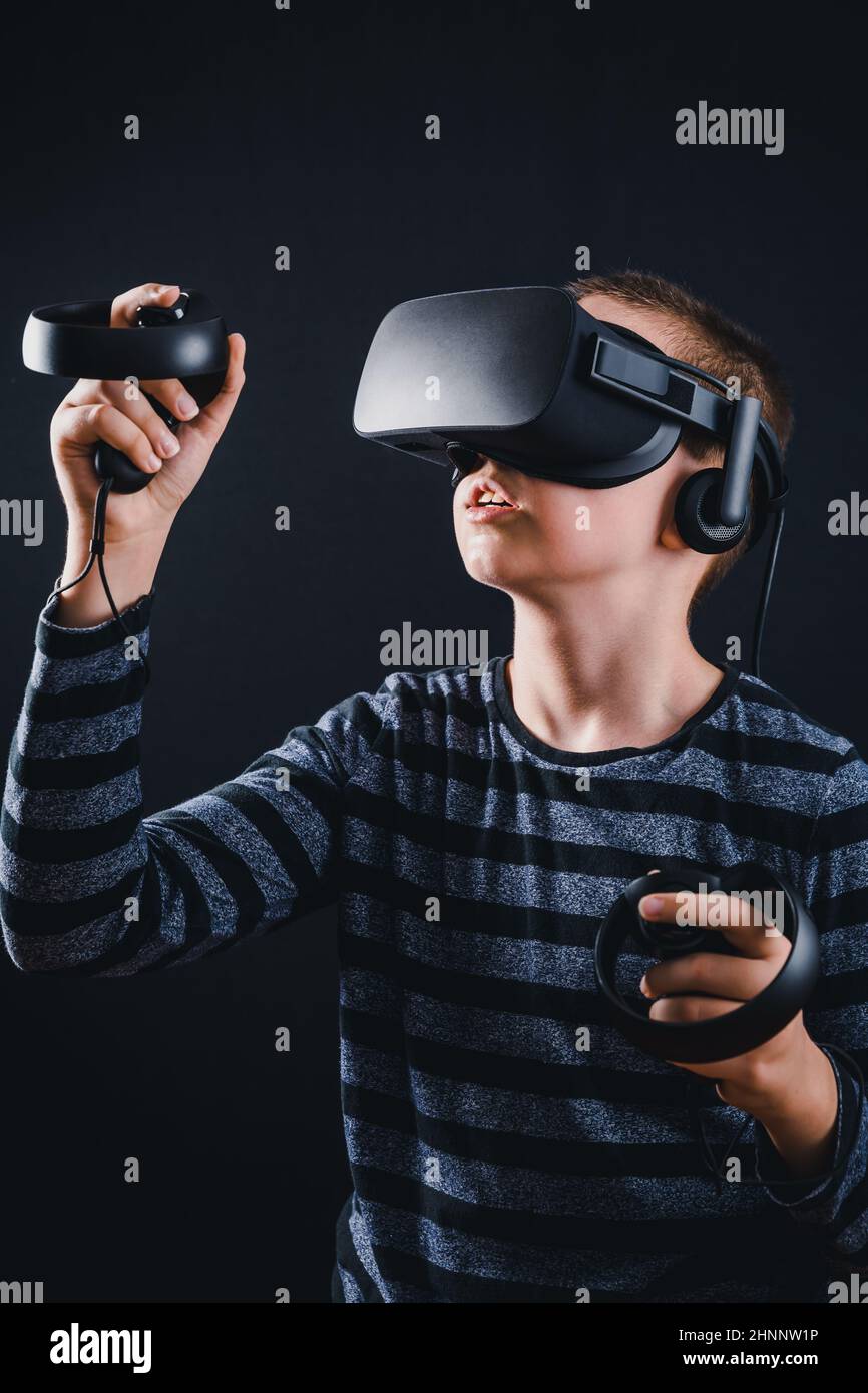 Teenager boy playing in virtual reality on black background Stock Photo