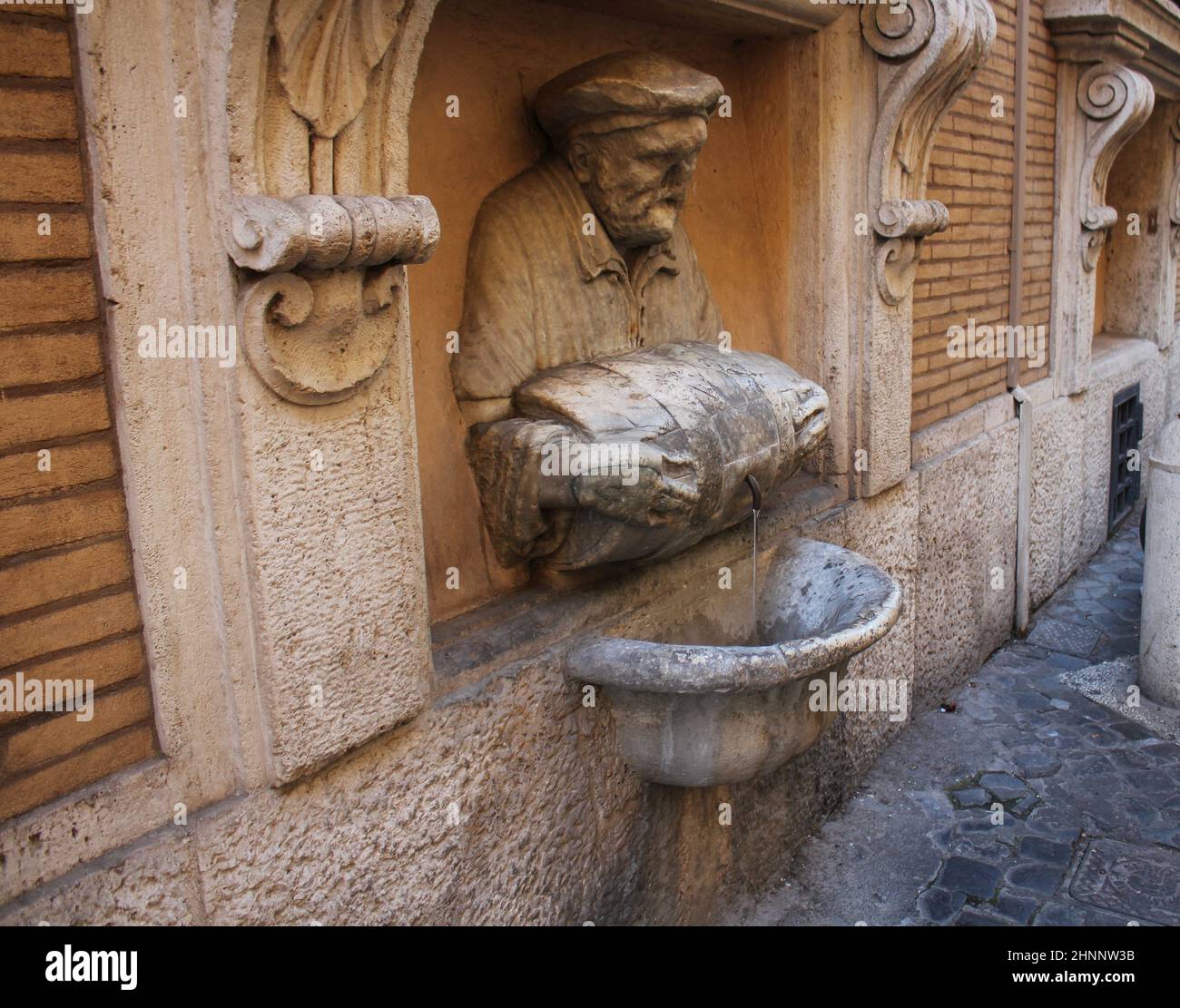 ROME, ITALY - December 28, 2018: Statue of an old man pouring water from a barrel used as a fountain nicknamed 'The Porter'. It was made in 1580 and used as a site to post satirical writings. Stock Photo