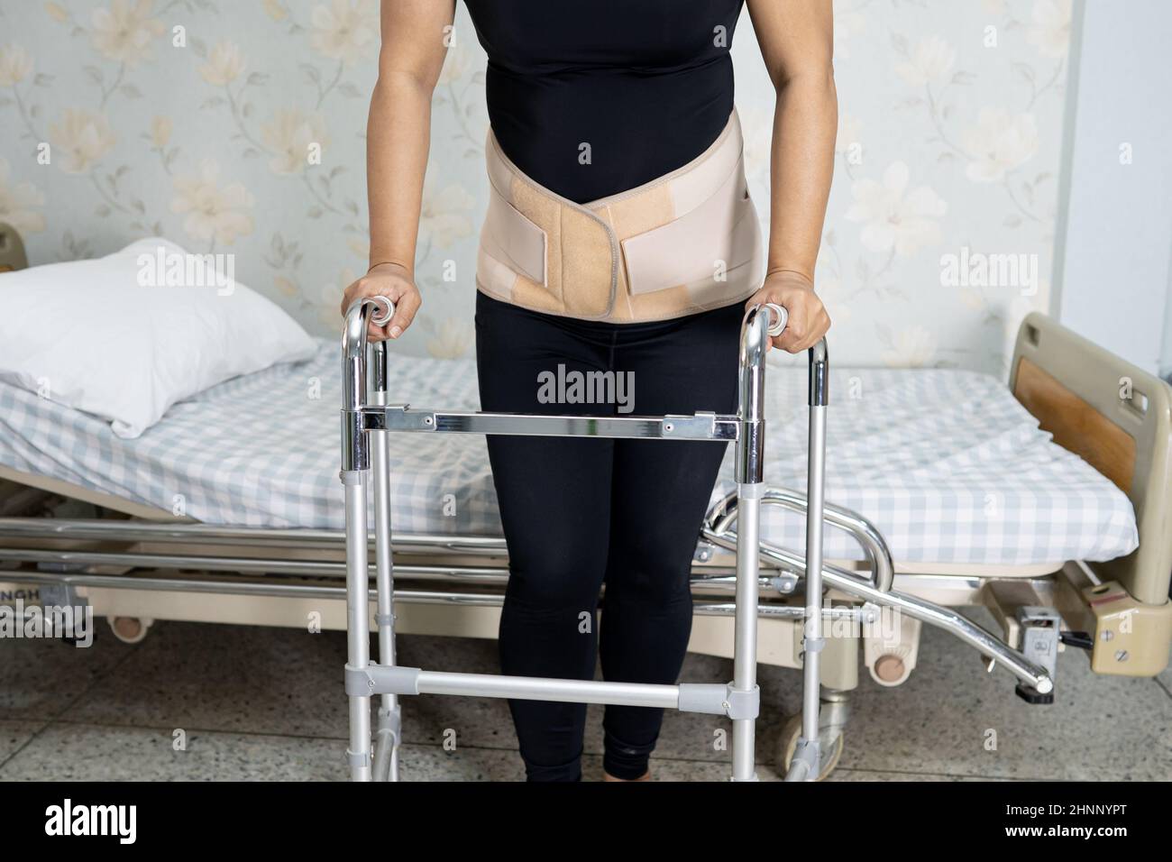 Asian lady patient wearing back pain support belt for orthopedic lumbar ...