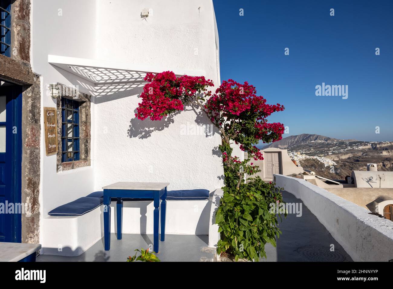 Red bougainvillea climbing on the wall of whitewashed house in Imerovigli on Santorini island, Cyclades, Greece Stock Photo