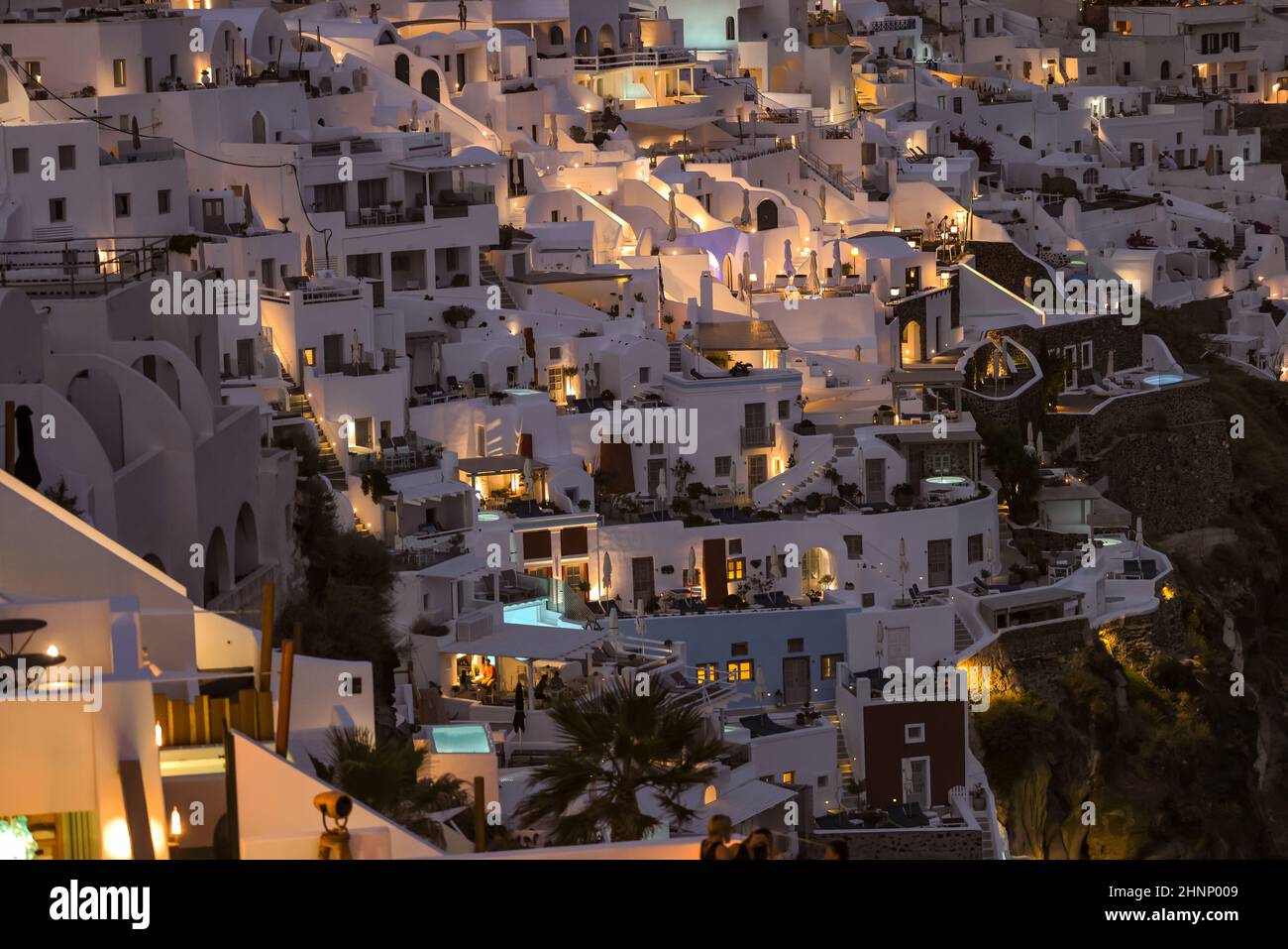Illuminated whitewashed houses with terraces and pools and a beautiful view in Imerovigli on Santorini island Stock Photo