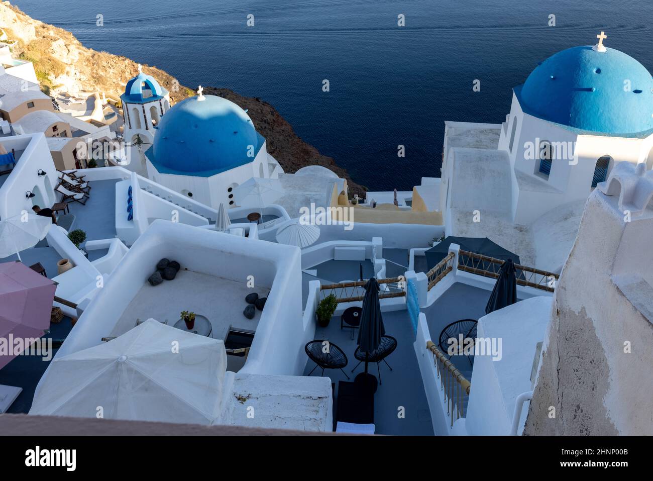 View from viewpoint of Oia village with blue domes of  greek orthodox Christian churches and traditional whitewashed greek architecture.  Santorini, Greece Stock Photo