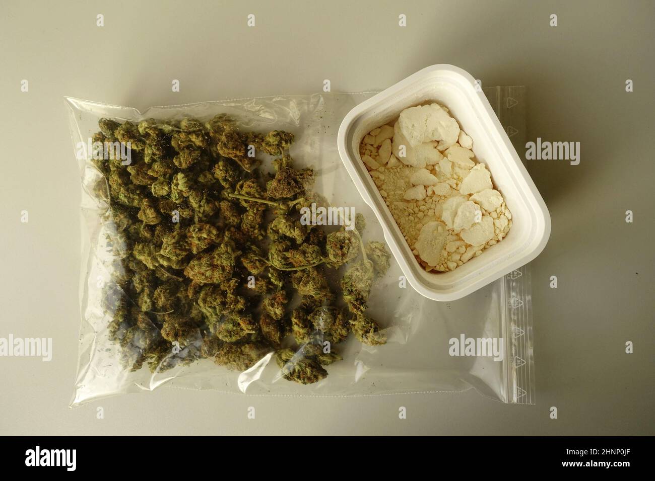 Dried Marijuana flower buds in a plastic bag and a jar with Amphetamine