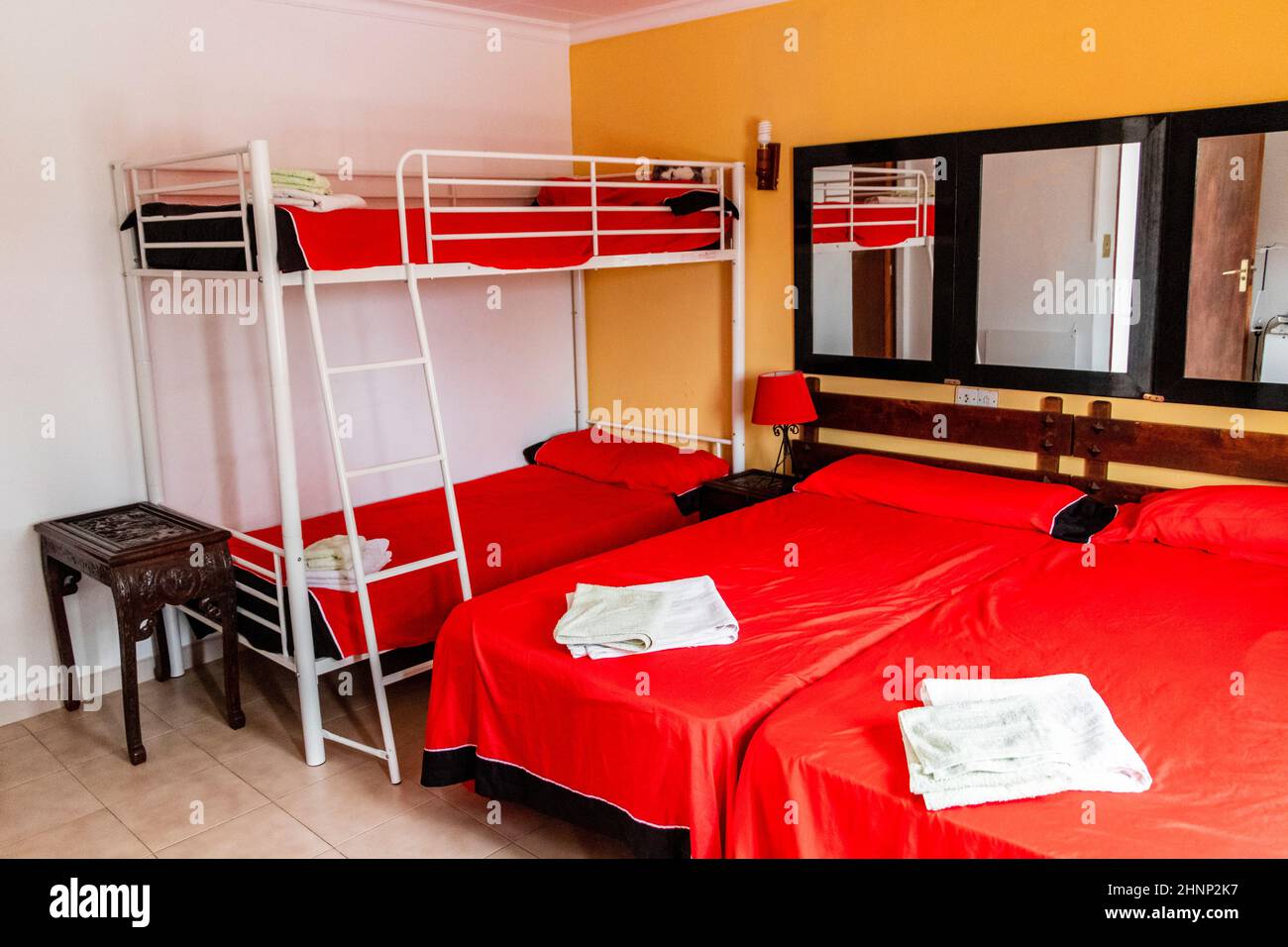 Red romantic hotel room hostel with yellow walls in Mallorca. Stock Photo