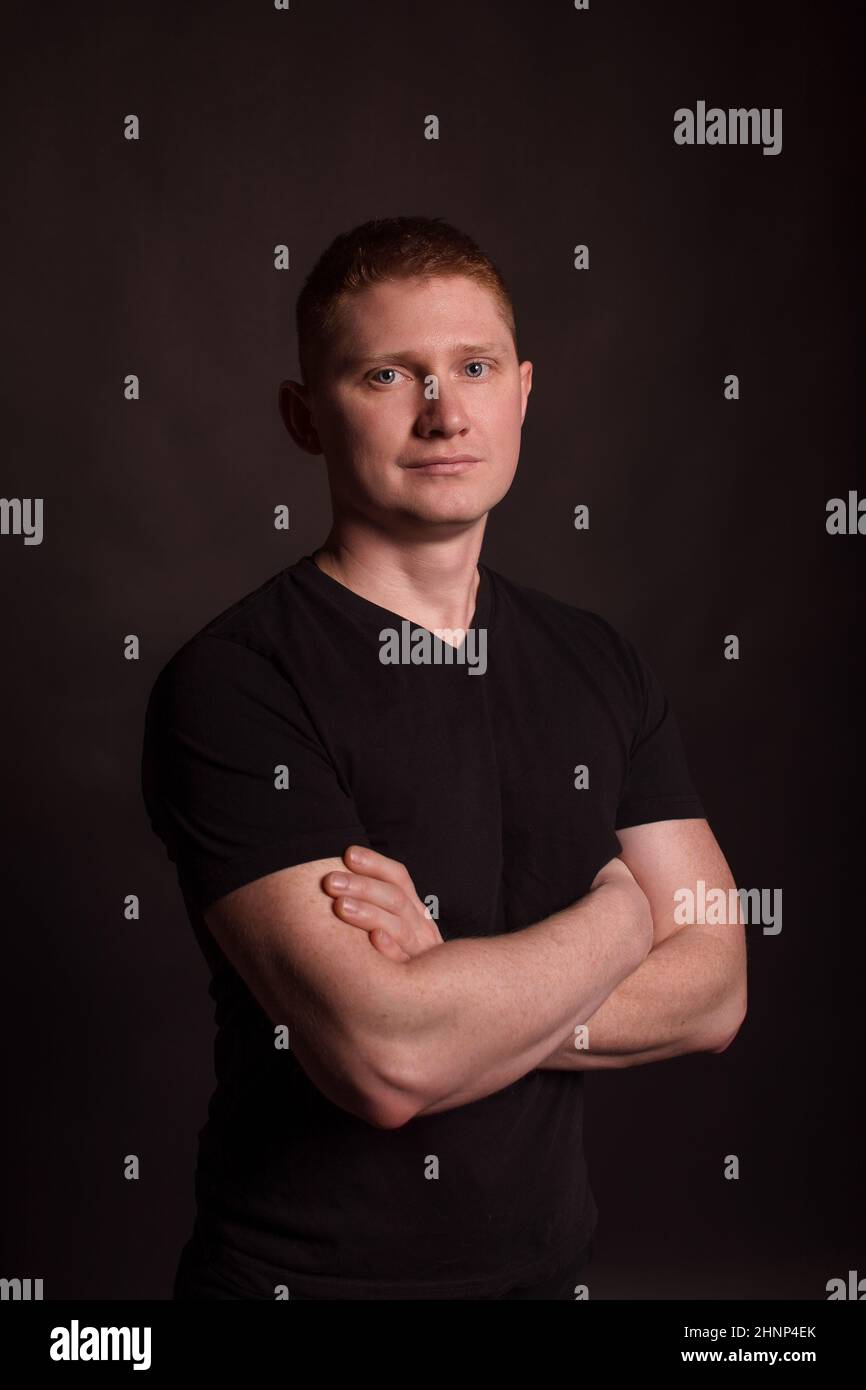 portrait of a red-haired guy on a black background . short hair Stock Photo