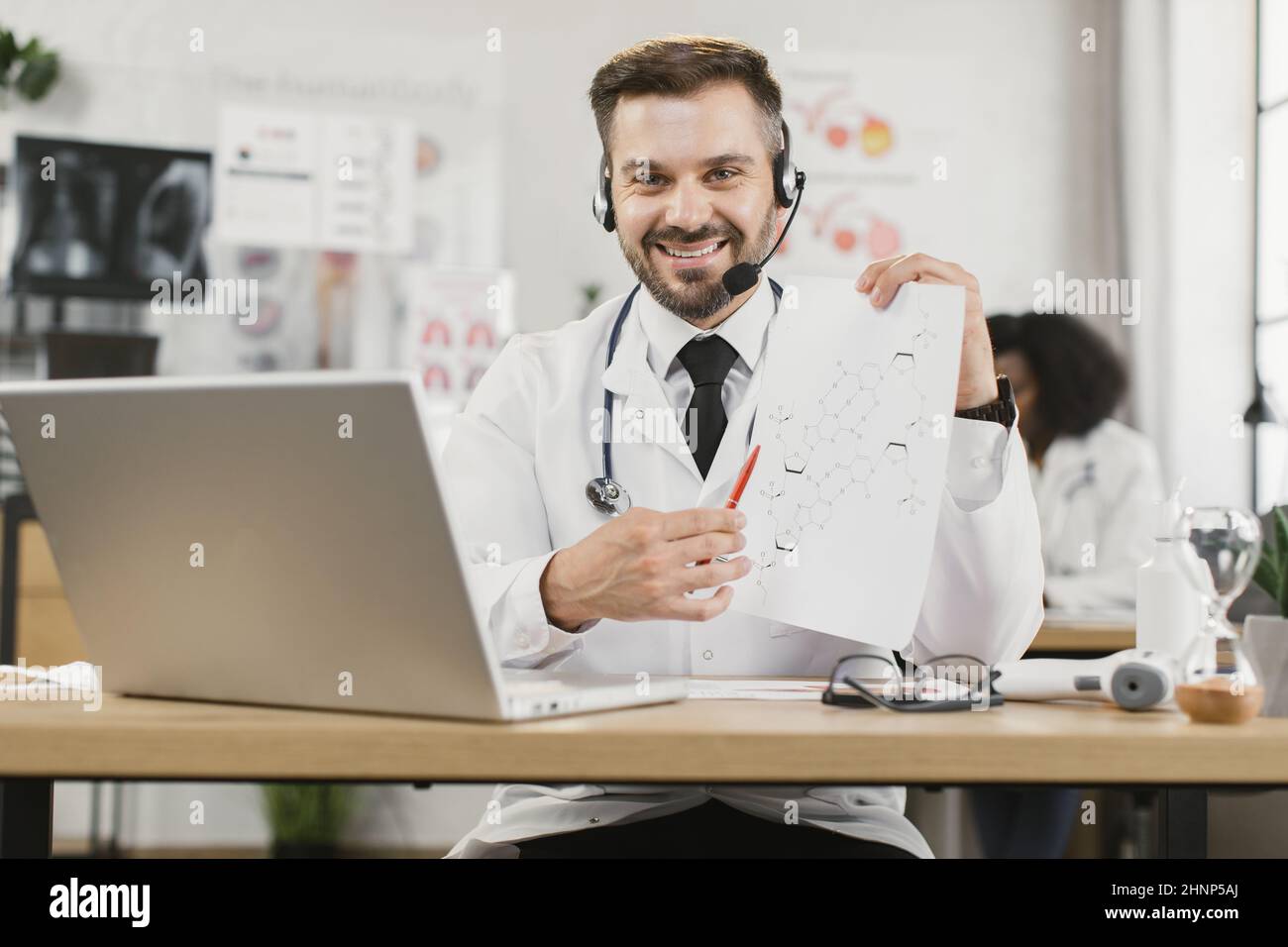 Qualified male doctor in headset talking about scientific researches in ...