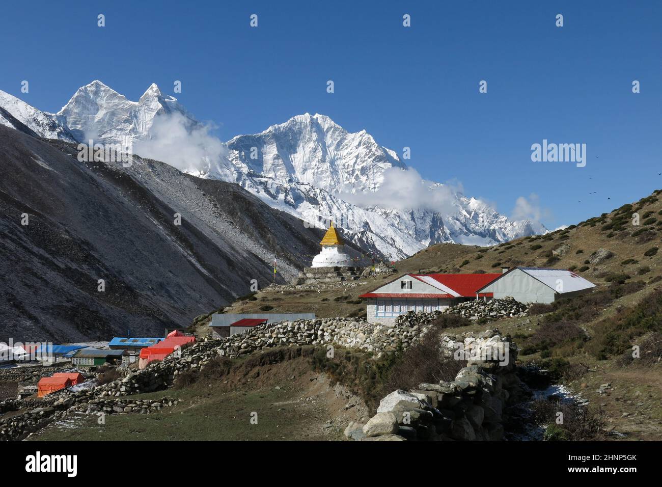 Stupa in the Sherpa village Dingboche and snow covered mountain Thamserku. Stock Photo