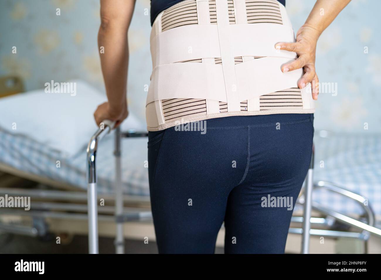 Asian lady patient wearing back pain support belt for orthopedic lumbar ...