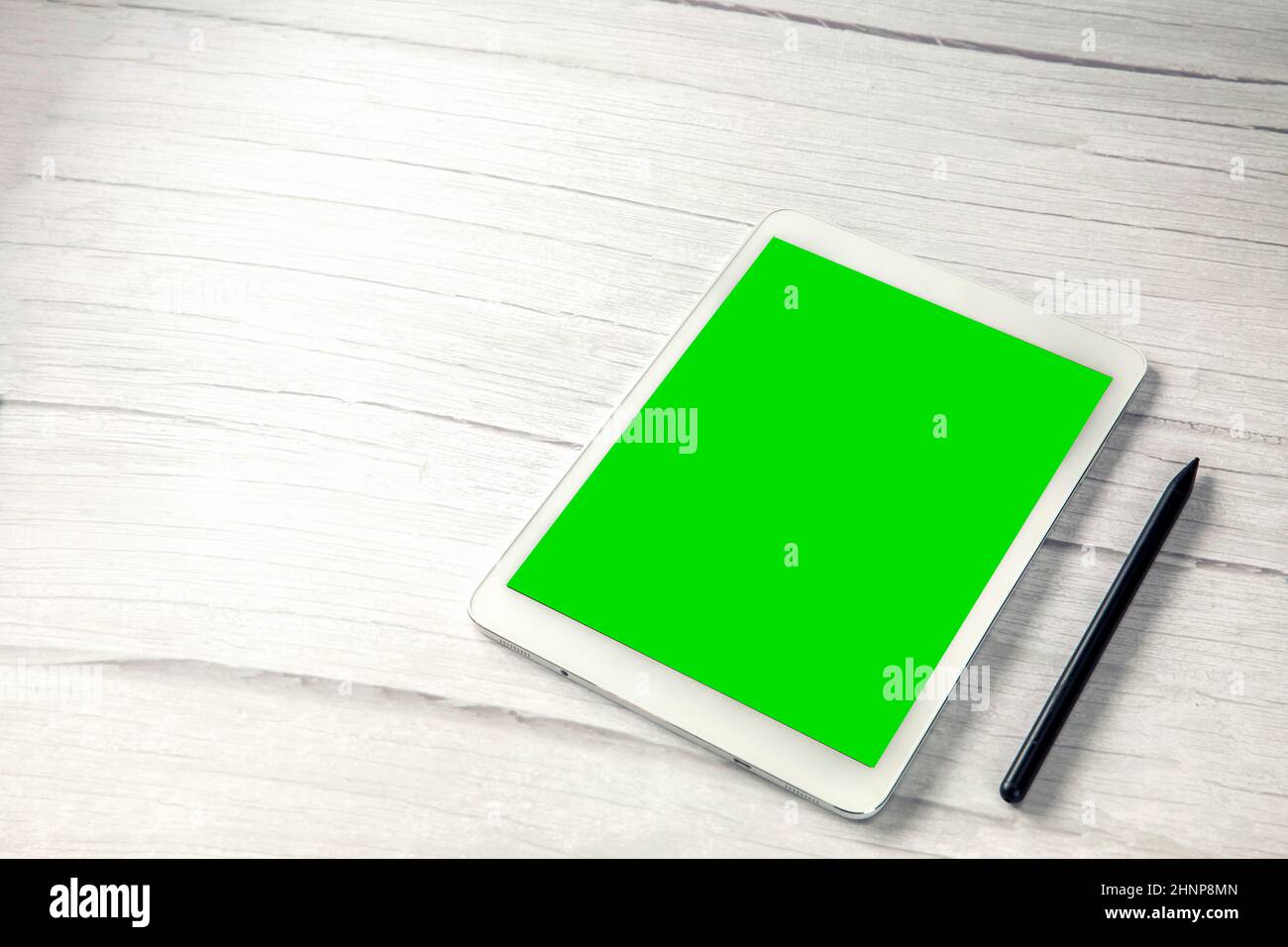 Digital tablet computer with pen and isolated green screen white wooden desk top view, copy space for film,movie, moving image Stock Photo