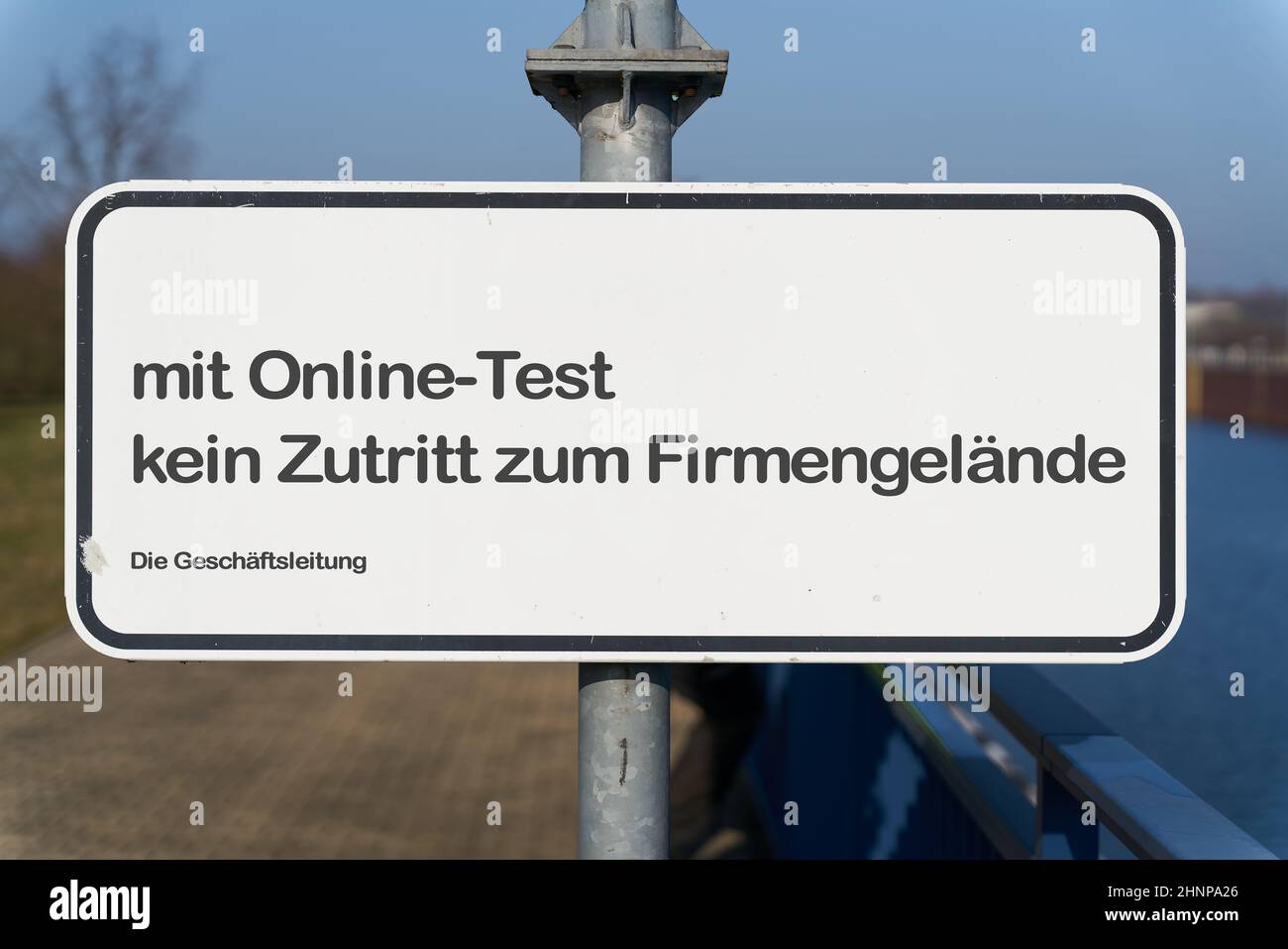 Restricted access at the entrance to a company site in germany during the Corona Pandemic. Translation: with online test no access to the company premises. The Management. Stock Photo