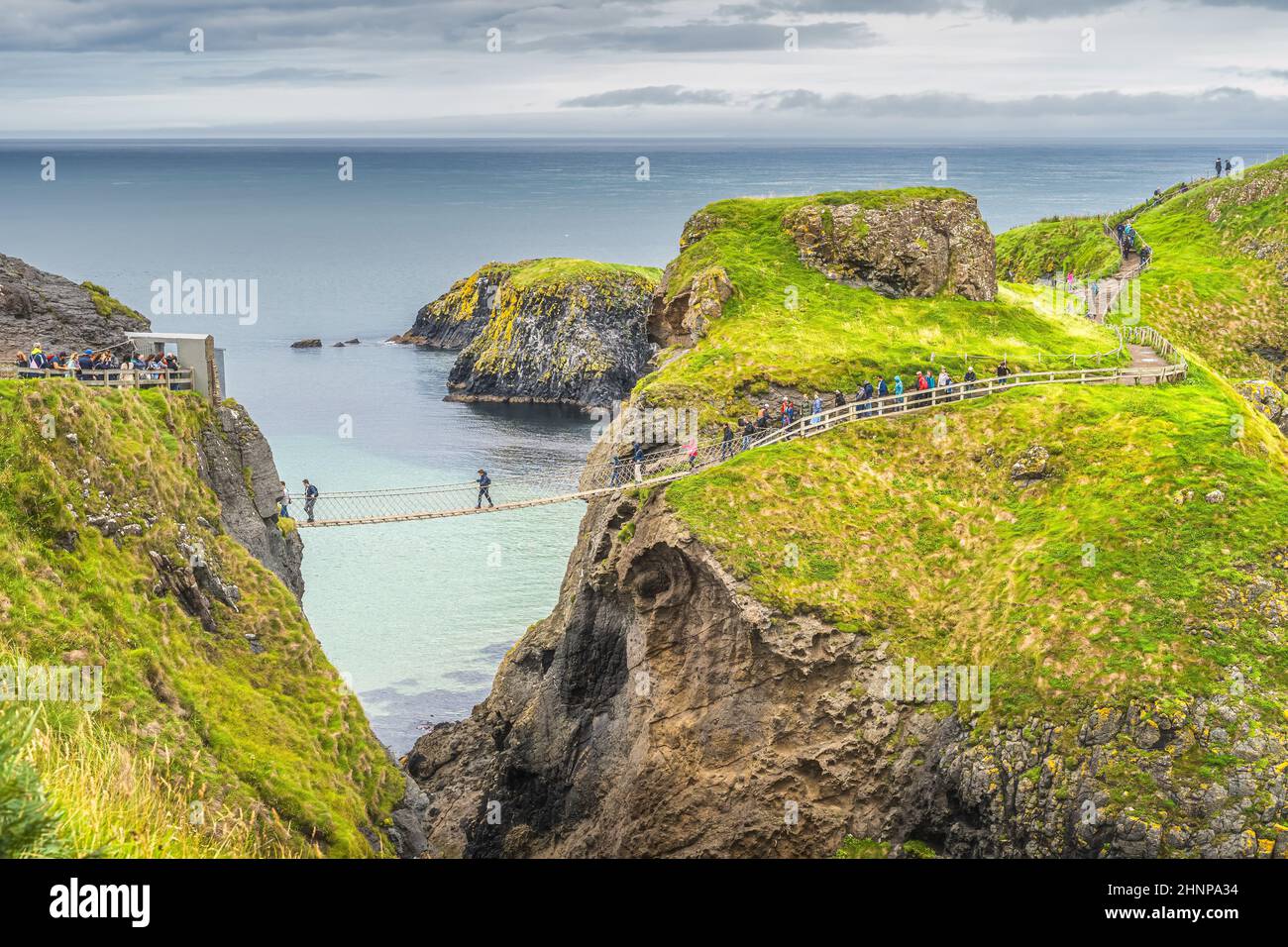 People queueing to crossing Carrick a Rede rope bridge to access island, Northern Ireland Stock Photo