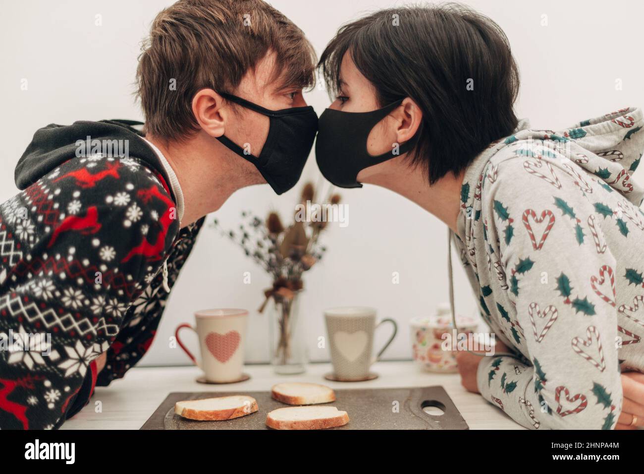 Girl and Boy Kissing in Masks on Coronavirus Quarantine Stock Photo