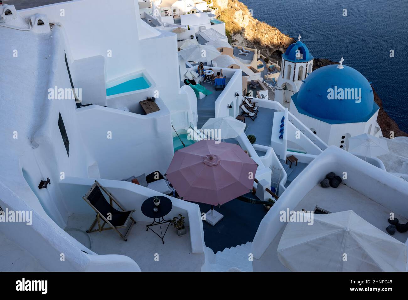 View from viewpoint of Oia village with blue domes of  greek orthodox Christian churches and traditional whitewashed greek architecture.  Santorini, Greece Stock Photo