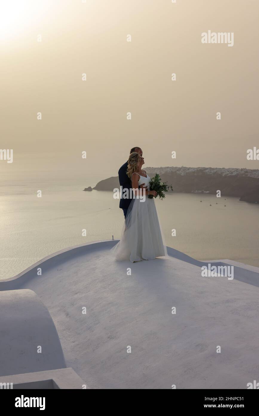 The bride and groom during a romantic photo session in Imergovigli on Santorini Island. Stock Photo
