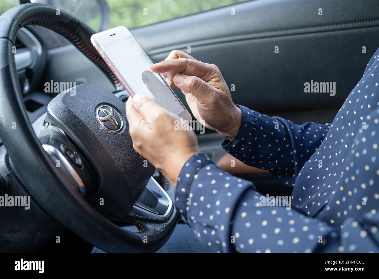 Bangkok, Thailand, July 1, 2021 Holding iPhone in toyota sienta car to communication with family and friends. Stock Photo