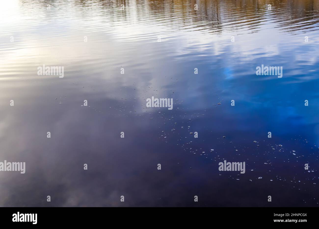 Detailed close up view on water surfaces with waves and ripples and the sunlight reflecting at the surface Stock Photo