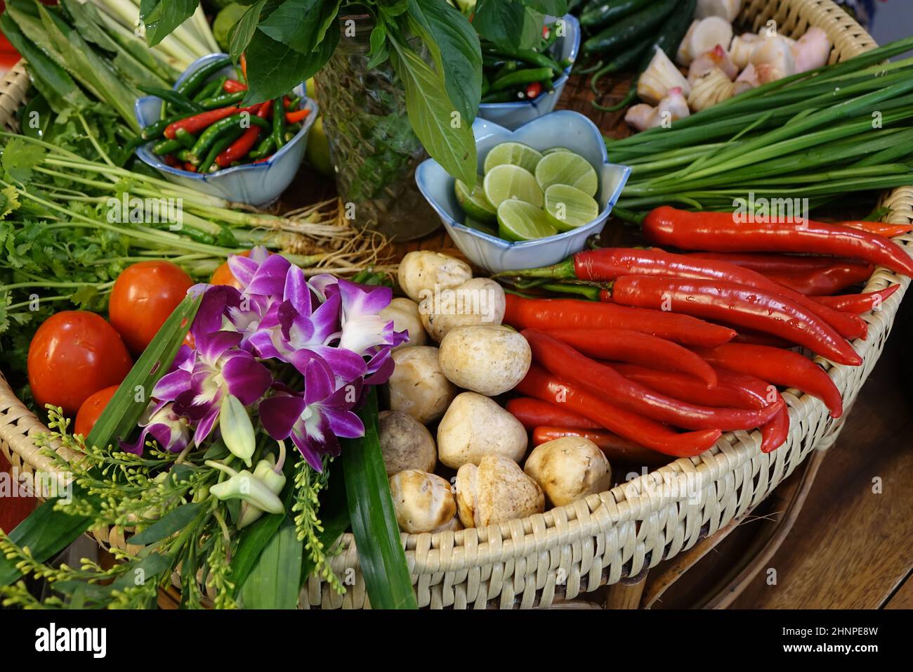Colourful, healthy and fresh fruits and vegetables in wooden basket, focus on top of the violet flowers, Bangkok, Thailand Stock Photo