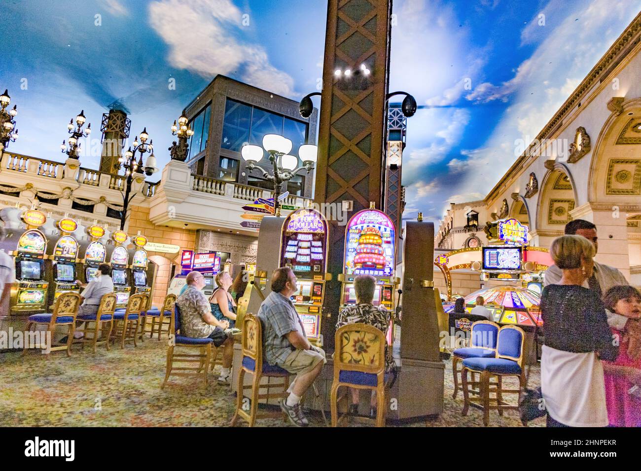 Gamblers sitting i the casino playing with slot machines Stock Photo