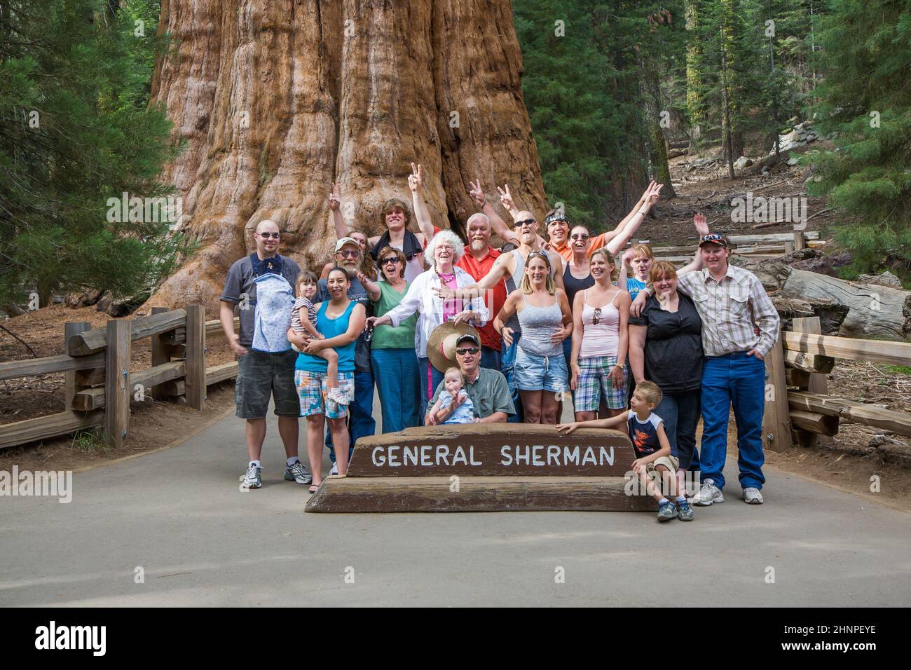 happy family enjoys posing in sequoia national park in fromt of general sherman sequoia tree Stock Photo