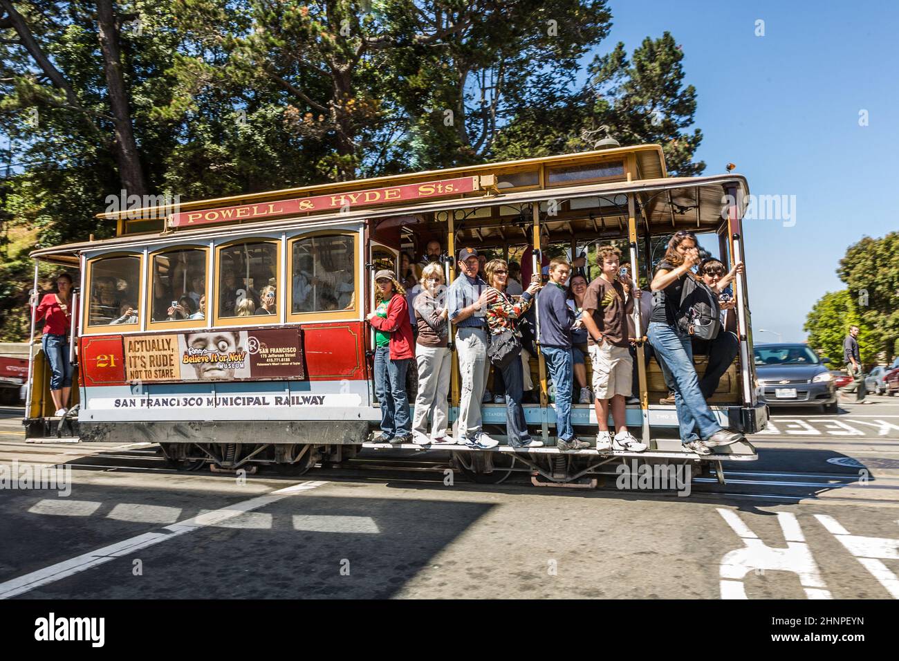 the Cable Car passes the Powell street in rush hour full of passengers