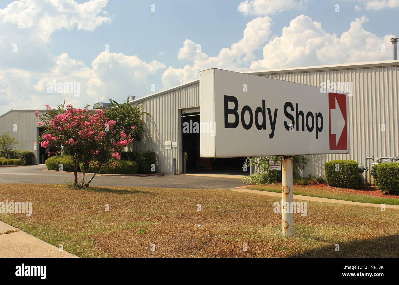 Body Shop Sign at Car Dealership With Blue Sky Stock Photo